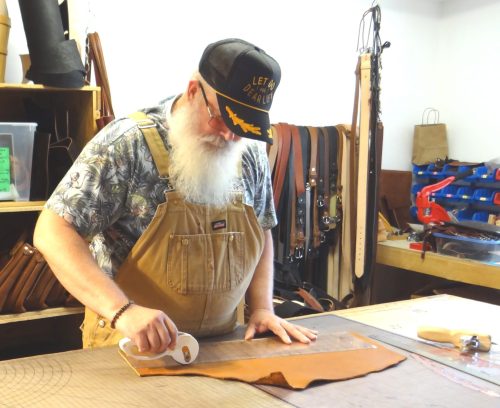 WES KEATING THE CARILLON 

Allen works on a piece of cow hide at his Cedar Avenue shop in Niverville.