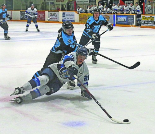 Ty Paisley reaches for a puck while falling down in game action against the Winnipeg Blues in 2022. (Cassidy Dankochik Carillon Archives)